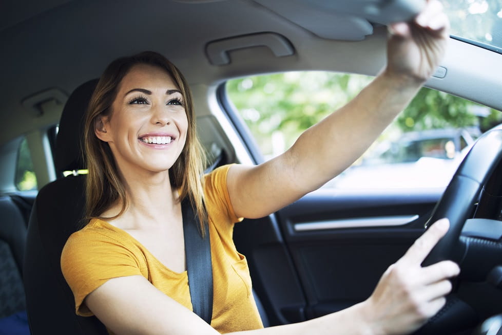 mujer viendo su espejo retrovisor