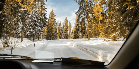 Une voiture roulant sur une route enneigée
