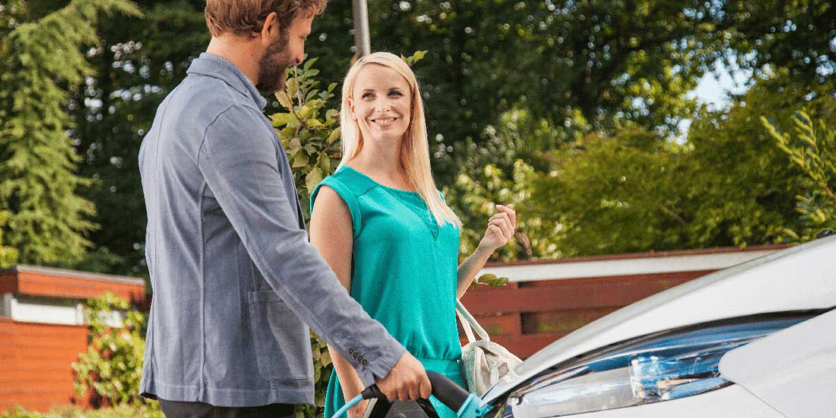couple branchant une voiture électrique pour la recharger