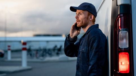 Worker on phone by van