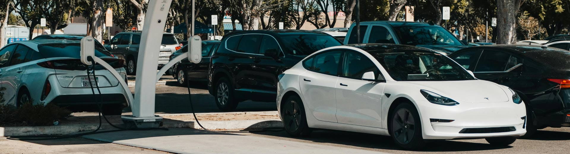 Electric vehicles at a charging station, showcasing Ayvens’ flexible EV car subscription and leasing services for urban drivers