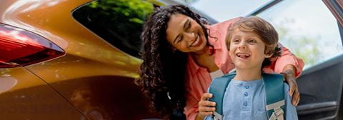 Woman and kid in front of car