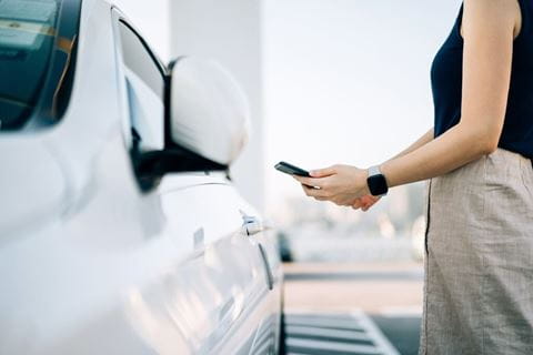 Mulher a tirar fotografia a um carro