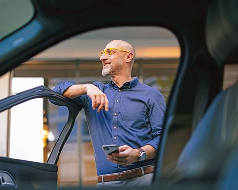 Man standing outside car with door open