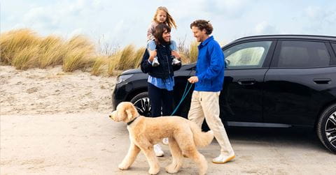 une famille à côté d'un SUV