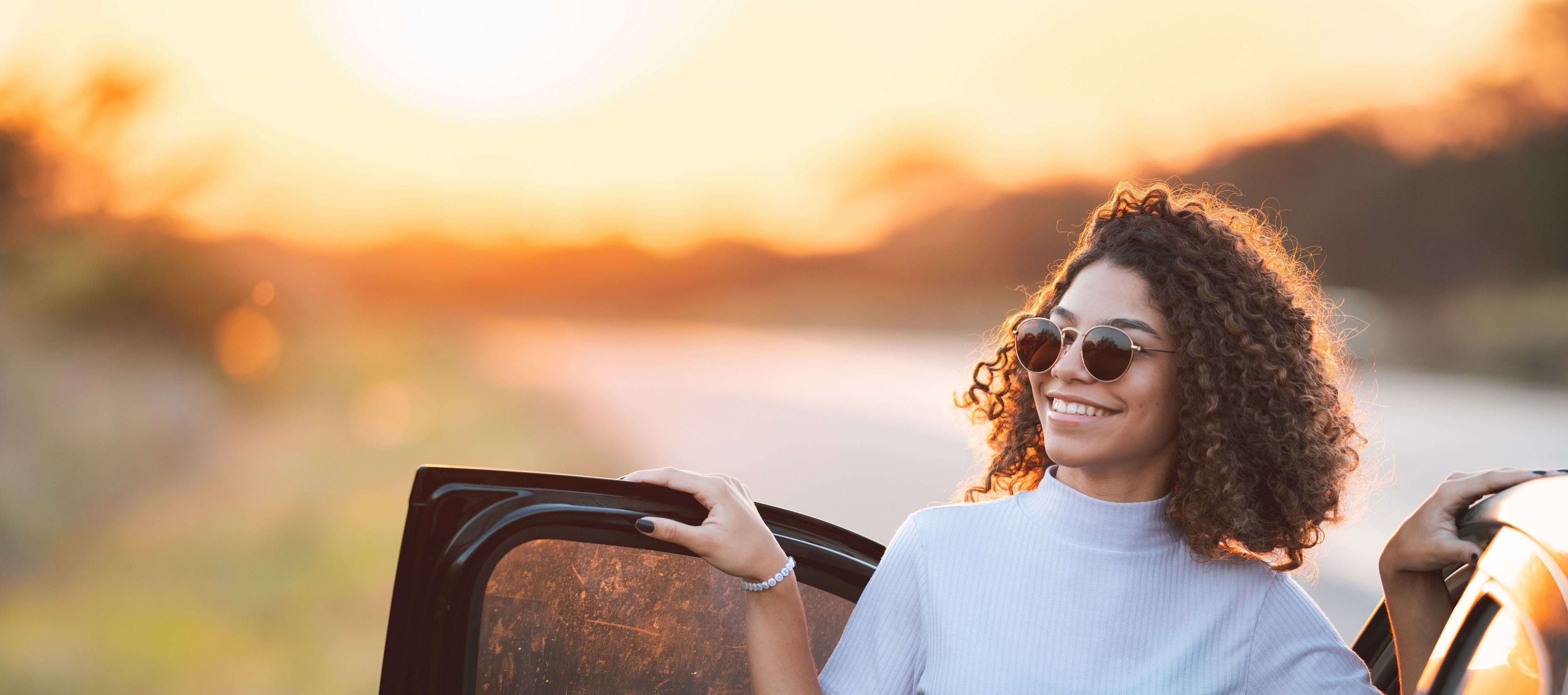 Women standing next to vehicle during sunset