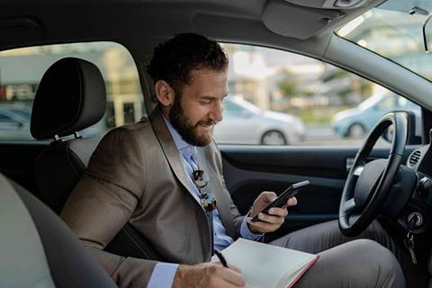 man writing in car