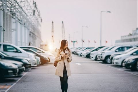 Mulher em parque de estacionamento a escolher o carro