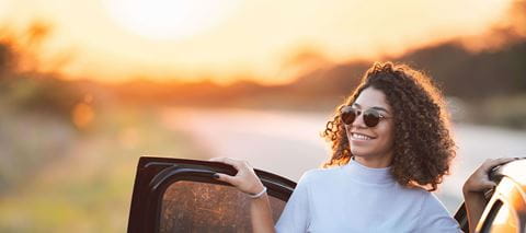 Women standing next to vehicle during sunset
