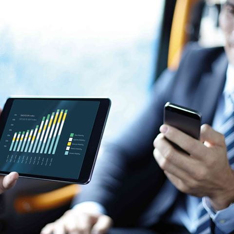 man on public transport looking at graph on tablet